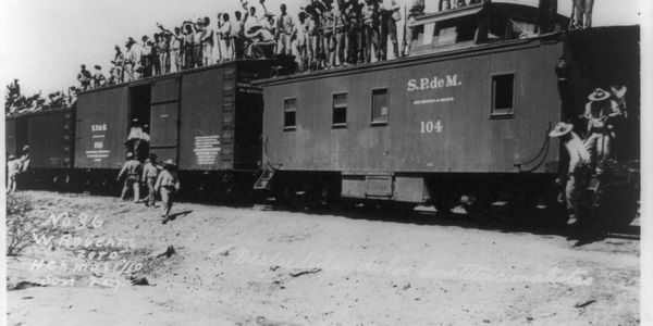 Soldiers standing on top of railroad cars