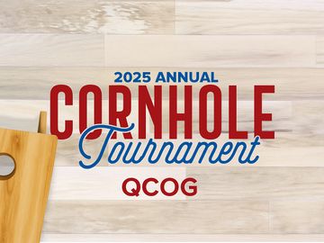 2025 Annual Cornhole Tournament announcement with a wooden cornhole board on a light wood floor.