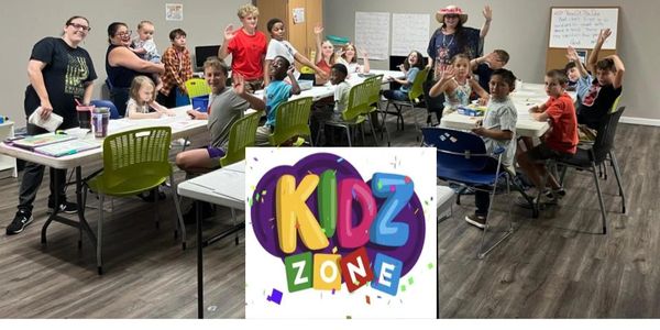 Children and teachers happily engaging in a classroom labeled Kidz Zone.