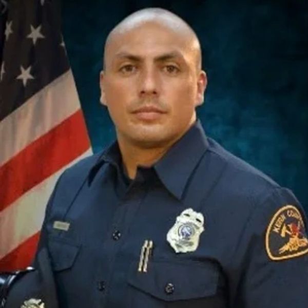 Portrait of a serious firefighter in uniform with an American flag background.