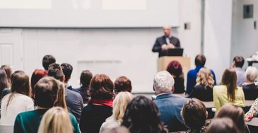 Audience attentively listening to a speaker at a seminar or conference.