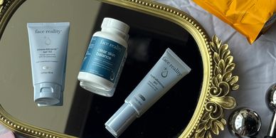 Three Face Reality skincare products displayed on a decorative gold mirror.