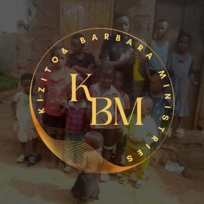 Group of children and adults standing outside a rustic building with KBM logo overlay.