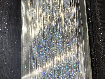 Shimmering silver tinsel with holographic sparkles on a dark background.