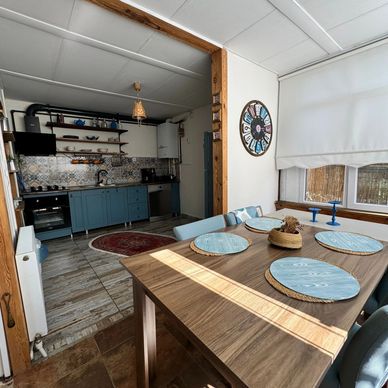 Cozy kitchen and dining area with natural light and rustic decor.
