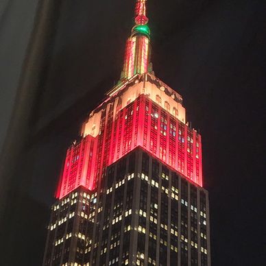 Empire State Building lit up in red and green at night.