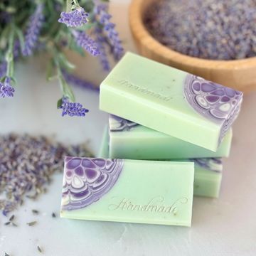 Handmade lavender kaleidoscope soaps with green and purple swirls, embossed with "Handmade."