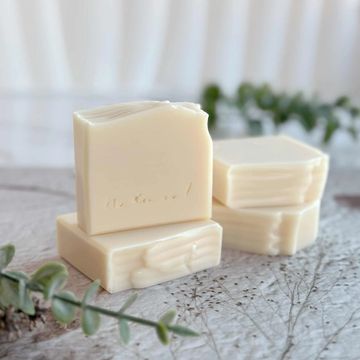 Four handmade sake soap bars. One stands upright with "Natural" engraved; others are stacked. 