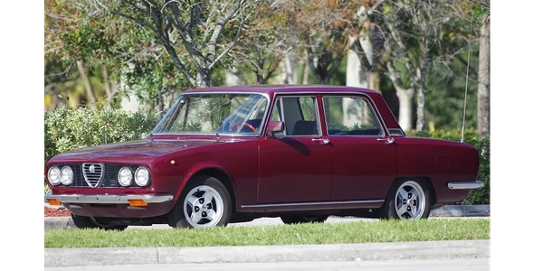 Classic maroon Alfa Romeo sedan parked outdoors.