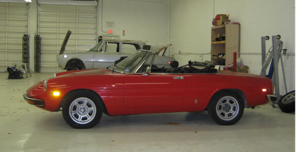 Red convertible sports car in a garage.