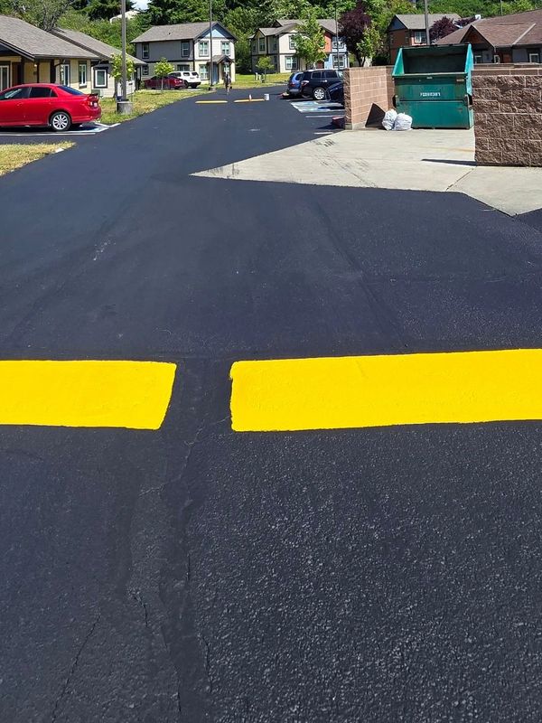 Newly sealed asphalt road and freshly painted speed bumps in a Tacoma housing development.