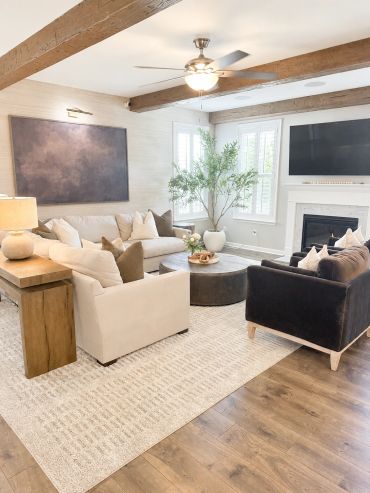 Bright modern living room with neutral tones and wooden beams.