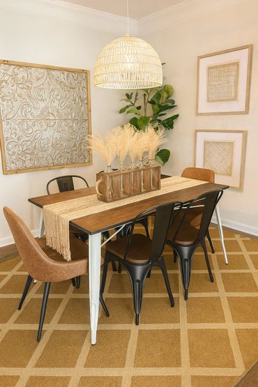 Warm dining room with wooden table, mixed chairs, and neutral decor.