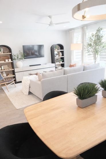 Bright modern living room with light wood furniture and large windows.