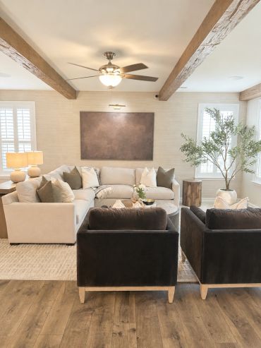 Cozy living room with neutral tones and rustic beams.