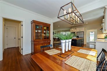 Hardwood floors and white trim throughout the dining room and adjacent space.