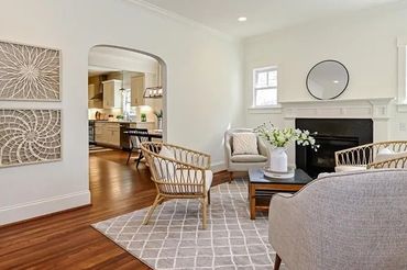 Patterned rug defining the seating area in a living room with hardwood floors.