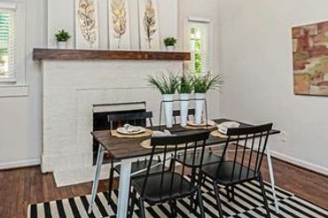 Furnished dining space for rent featuring a modern light fixture, neutral walls, and dark hardwood floors.