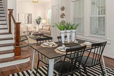 Dining area in a [type of rental property] with a view into a common living space.