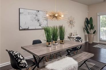 Dark hardwood floors contrasting with the light-colored walls and the light wood tabletop.