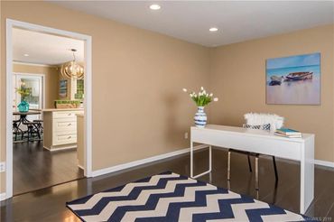 Open doorway leading into a kitchen with light wood cabinets and a table with chairs.