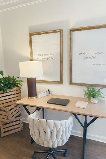 Cozy workspace with a wooden desk, plush chair, and inspirational framed quotes on the wall.