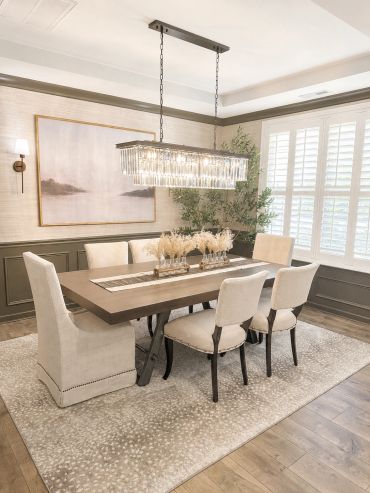Elegant dining room with crystal chandelier and neutral tones.