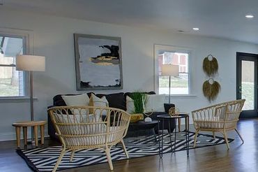 Dining room with a dark rectangular table and chairs, a modern sputnik-style chandelier, and windows.