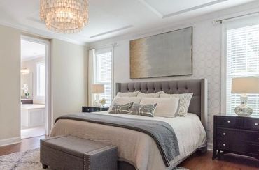 Modern bedroom with a tufted headboard and chandelier.