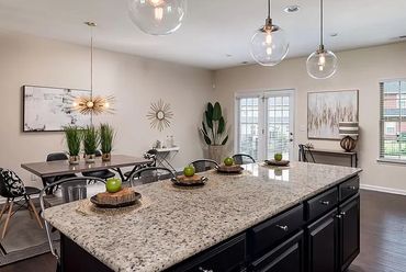 Green apples arranged on decorative plates on the kitchen island, adding a pop of color.