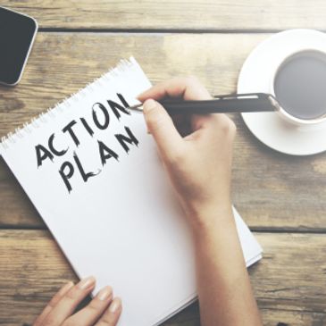Writing 'Action Plan' on a notepad.