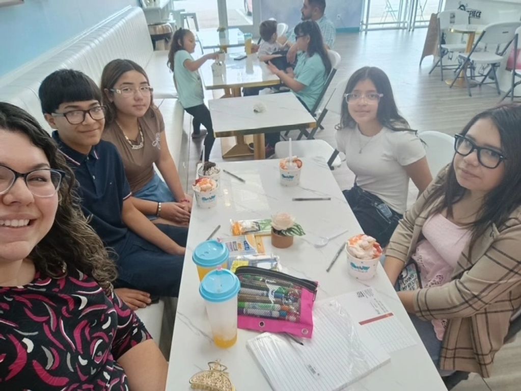 Group of young people enjoying desserts at a cafe table.