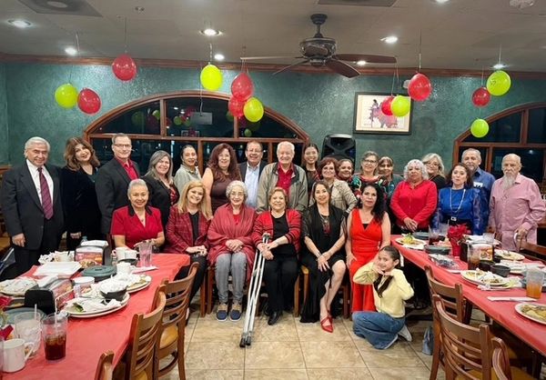 Large group of people gathered in a decorated restaurant for a celebration.