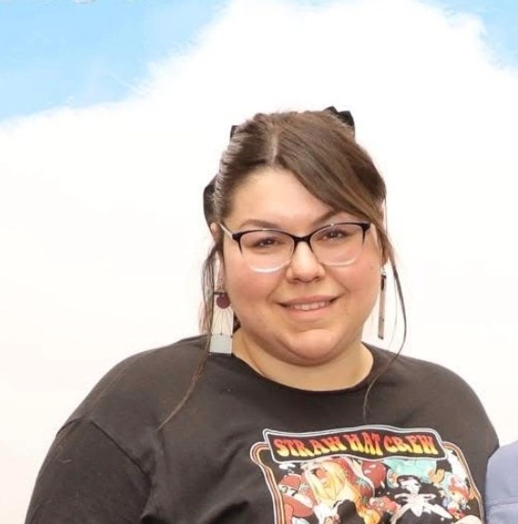 Smiling woman wearing glasses and a graphic t-shirt.