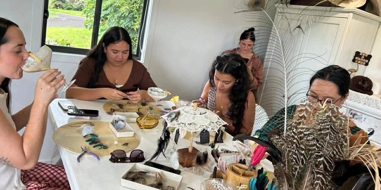 A group of women crafting with feathers and drinking cocktails at a table