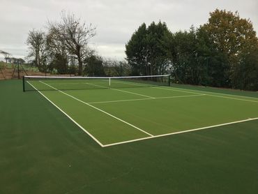 A tennis court on a grassy area