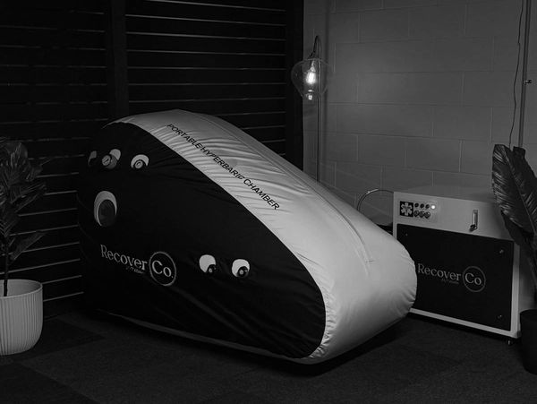 Portable hyperbaric chamber labeled RecoverCo.