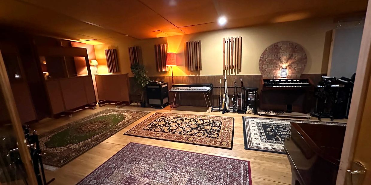 Cozy music studio with guitars, keyboards, and rugs.