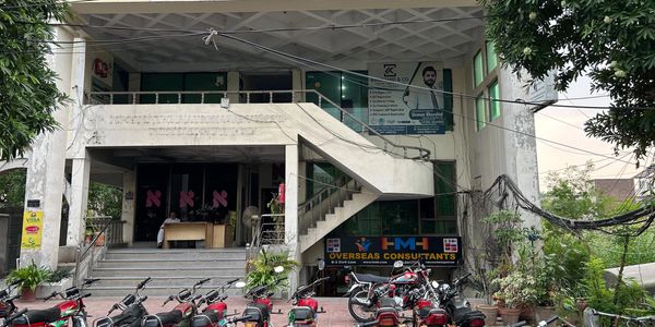 Building entrance with motorcycles parked outside and a staircase leading up.