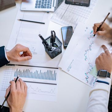 Two people analyzing financial charts and graphs at a desk.