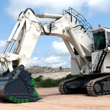 Large white excavator with a heavy-duty bucket on a construction site.