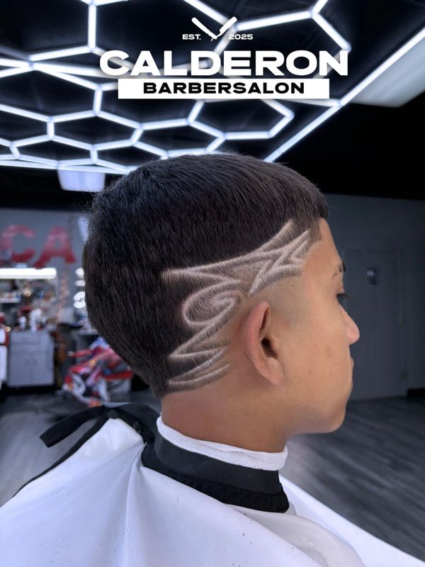 Modern haircut with intricate shaved designs at Calderon Barbersalon.