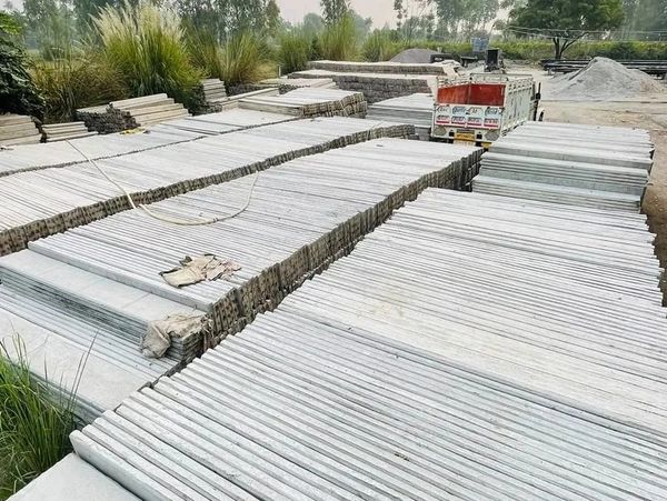 Stacks of concrete poles arranged outdoors at a storage yard.