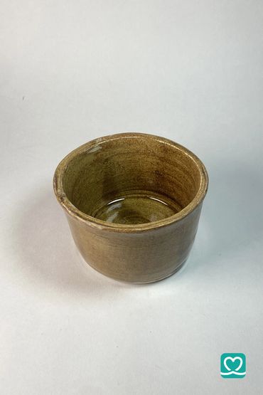 Handcrafted brown ceramic cup with a glossy finish.
