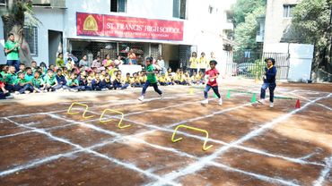 Children race during a sports event at St. Francis' High School playground.