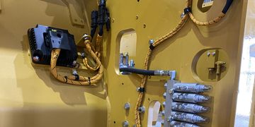 Yellow electrical wiring and connectors inside industrial machinery.