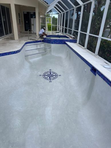 Empty swimming pool and raised spa with a light interior finish, blue waterline tile and compass mos
