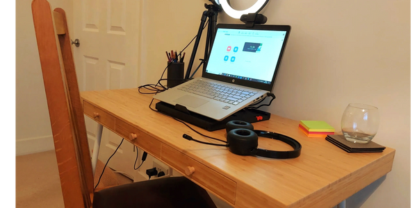 Laptop, headphones and ring light on a desk. My online therapy space.