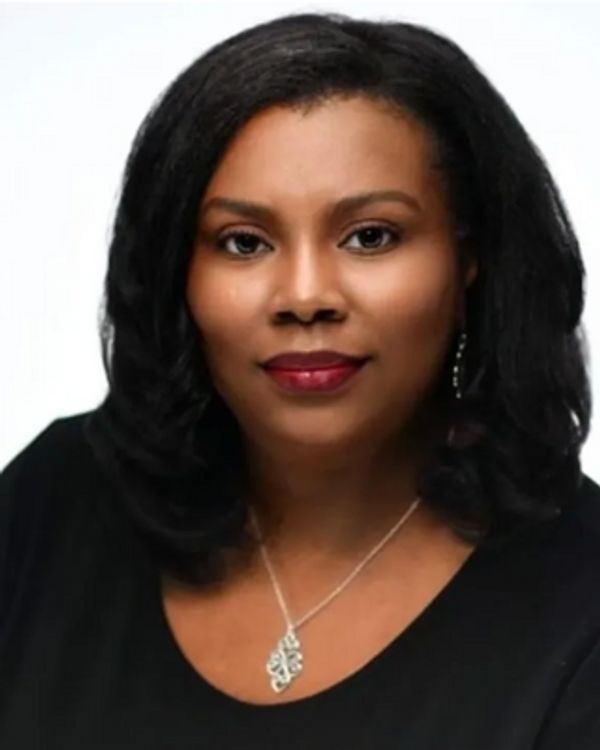 Portrait of a woman with black hair and a silver necklace.