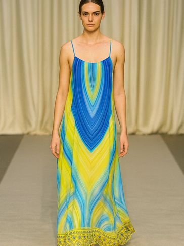 Model wearing a flowing blue and yellow maxi dress with thin straps.